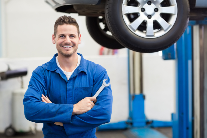 Certified mechanic smiling in a professional auto repair shop in Halifax