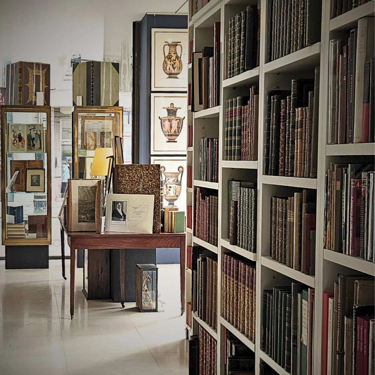 Interior of Attic Books showing tall shelves lined with rare leather-bound volumes and glass display cases