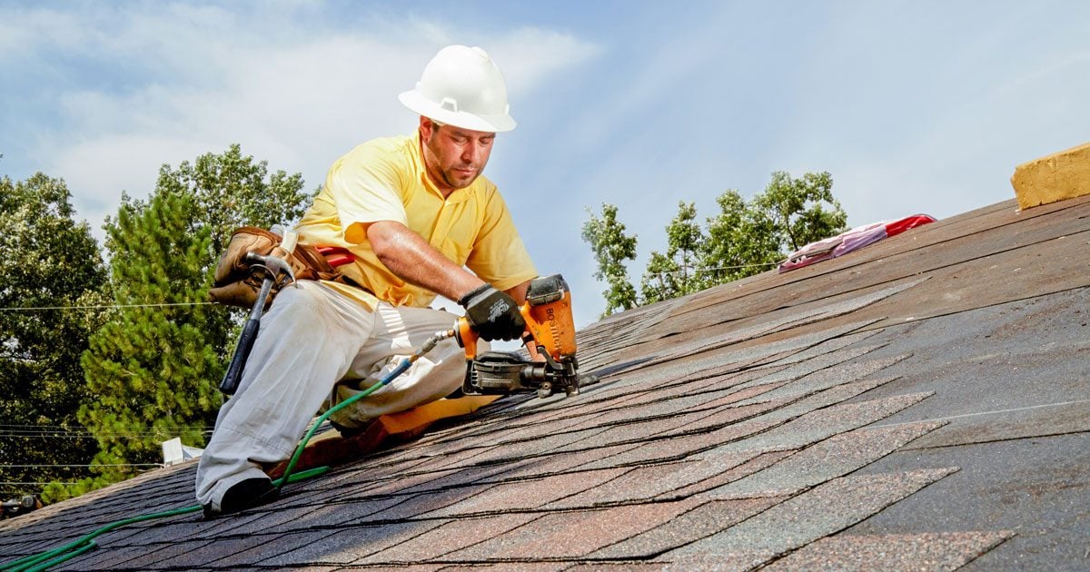 Berard Roofing professional installing asphalt shingles on a residential roof