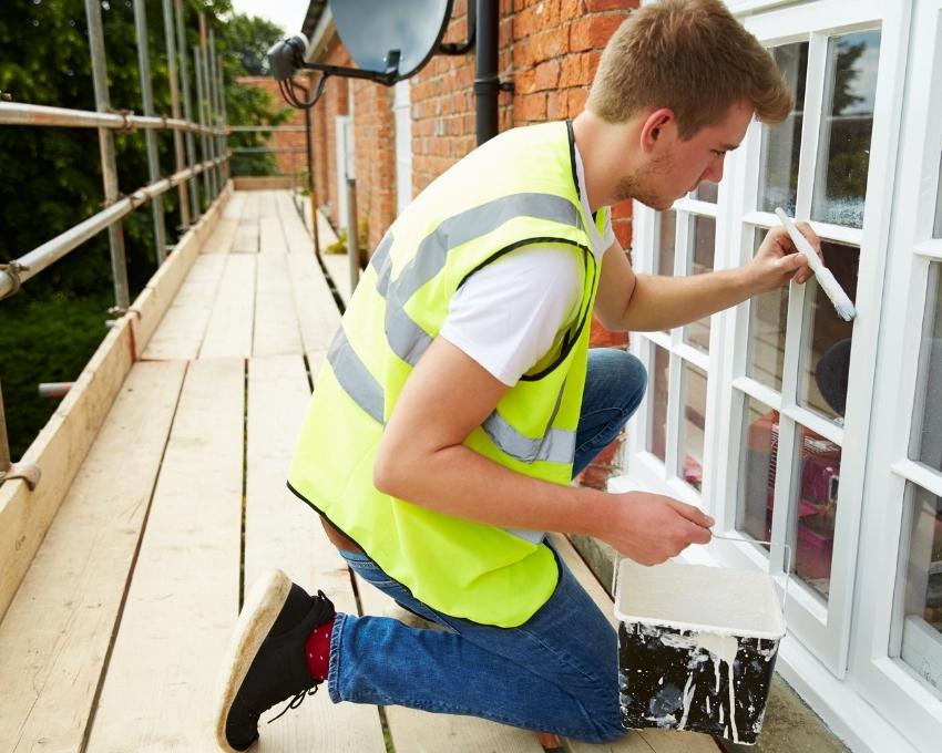 Professional handyman painting window trim