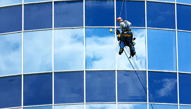 Professional window cleaner on high-rise building