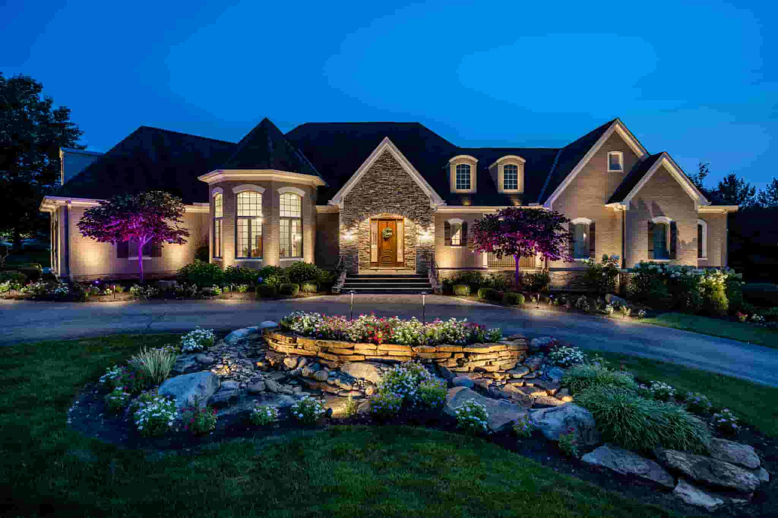 Beautiful home with outdoor landscape lighting at night
