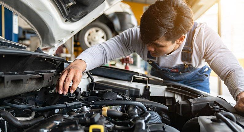 Certified mechanic working on car engine at Hodge's Service Center
