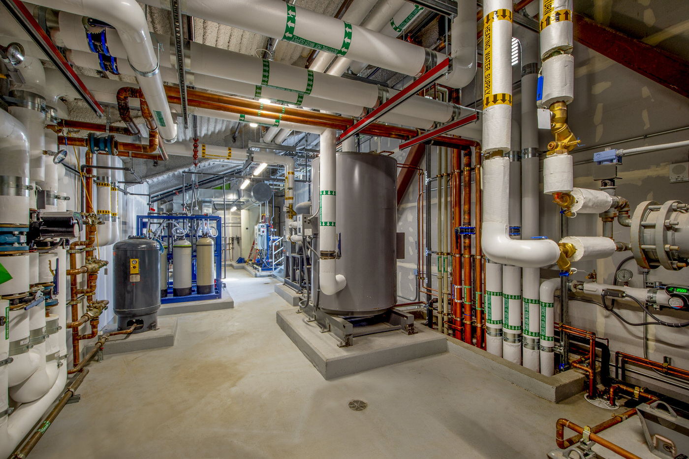 Commercial mechanical room with industrial plumbing and heating systems