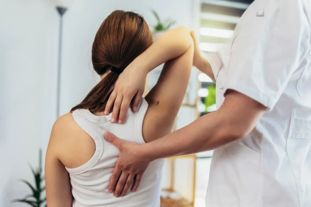 Chiropractor performing gentle spinal adjustment on a patient