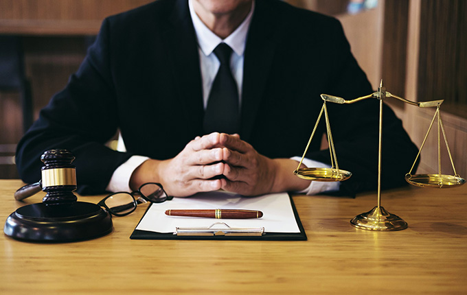Criminal defence lawyer with scales of justice in Winnipeg law office