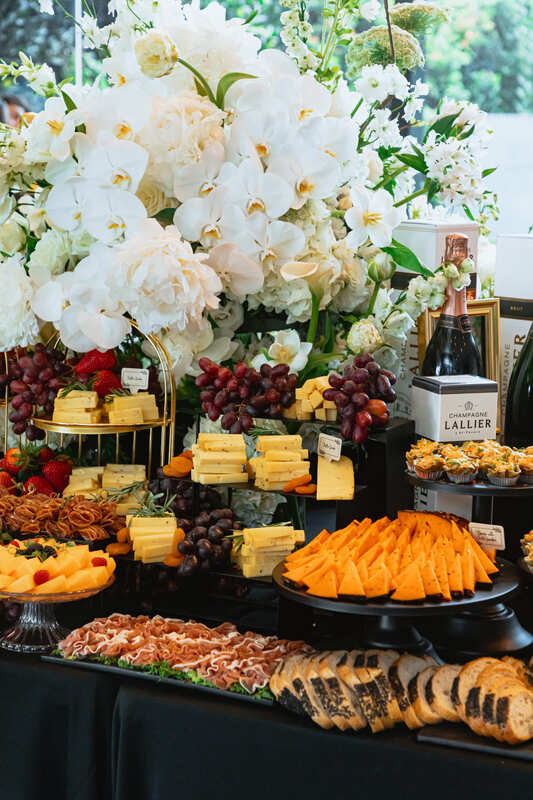 Elegant wedding catering spread with fresh flowers and gourmet appetizers
